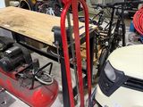 une photo d'un garage avec une tondeuse à gazon et un établi