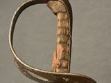 a close up of a sword with a metal handle on a table