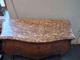 a marble top chest of drawers in the corner of a room