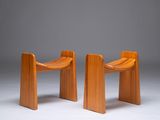 two wooden chairs sitting next to each other on a white surface