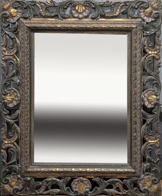 un gros plan d'un miroir accroché au mur, avec un cadre en bois