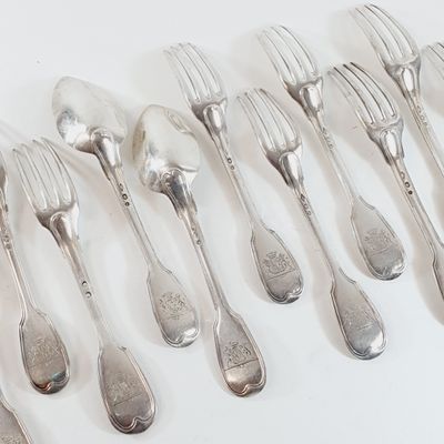 a lot of silver spoons and forks on a white table