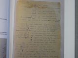 un livre ouvert à une page sur laquelle figure l'image d'une lettre manuscrite
