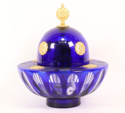 un bol en verre bleu orné d'un motif doré sur le dessus
