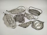 several silver metal objects are arranged on a white surface
