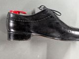 a pair of black shoes hanging on a wall