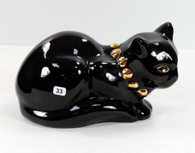 une figurine représentant un chat noir posée sur une surface blanche