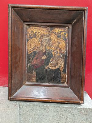 painting of the virgin and child in a wooden frame on a red wall
