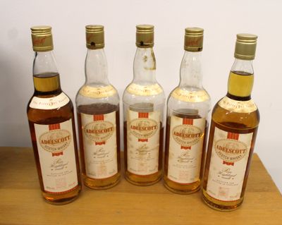 six bottles of whisky sitting on top of a wooden table