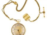 une image représentant une montre de poche en or avec une chaîne, sur fond blanc