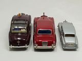 three toy cars are lined up in a row on a white surface