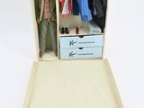 a doll in a suitcase with clothes in it