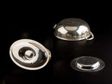 a silver object on a black table with a black background