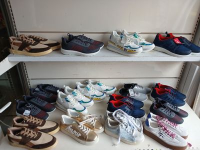many pairs of shoes on a shelf in a store