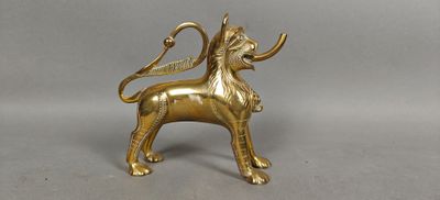 brass figurine of a lion with horns and a tail