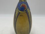 un vase jaune orné d'un motif bleu et rouge