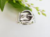 a close up of a silver ring with a face on it