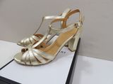 the gold shoes are on a white box on a table