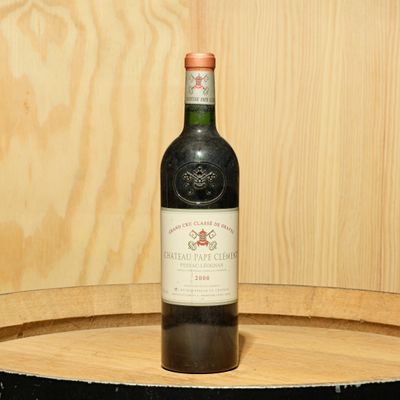 a bottle of wine sitting on top of a barrel