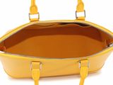 a close up of a yellow handbag on a white background