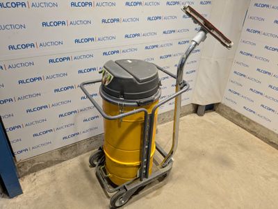 un aspirateur jaune et noir posé sur un chariot devant un mur