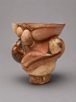 une photo d'un vase marron et blanc posé sur une table