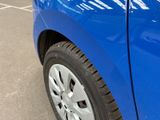 a close up of a blue car parked in a parking lot