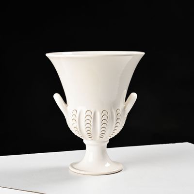 un vase blanc posé sur une table blanche