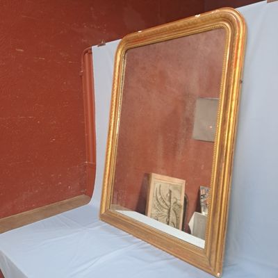 un miroir posé sur une table près d'un mur