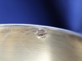 a close up of a metal pan with a hole in it
