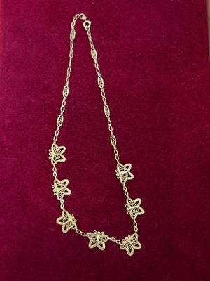 a gold necklace on a red velvet box