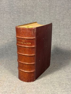 an old book with a brown cover sitting on top of a table