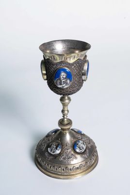 une coupe argentée et bleue posée sur un socle en argent