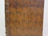 an old brown book with writing on it sitting on a white surface