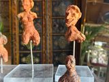 five clay sculptures of a woman and a man sitting on a table
