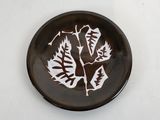 a plate with a picture of a leaf on it