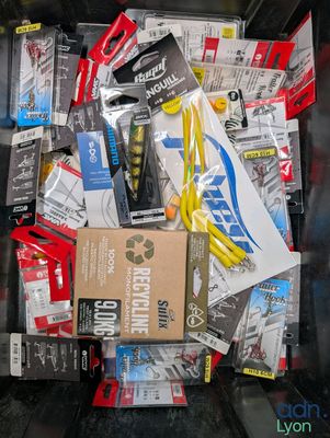 many different types of fishing lures in a bin