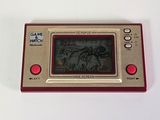 a red and gold electronic game on a white table