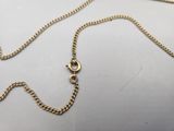 a close up of a gold chain on a white surface