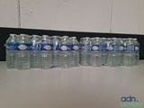 several bottles of water are lined up on a table