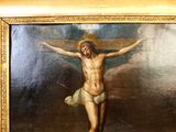 un tableau représentant Jésus sur la croix, dans un cadre doré