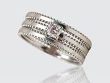 a close up of a ring with a diamond on it