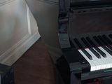 a piano in the corner of a room with a painting on the wall