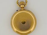 gold plated pocket watch on a white surface with a white background