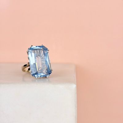 a close up of a blue topaz ring on a white pedestal