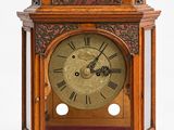 une horloge en bois posée sur une surface blanche