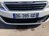 the front of a white car with a number plate on it