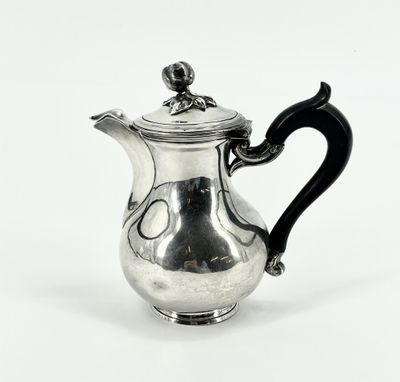 une théière en argent avec une anse noire sur fond blanc