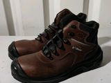 brown leather work boots with black laces on a white surface