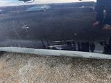 a reflection of a person standing in the reflection of a car
